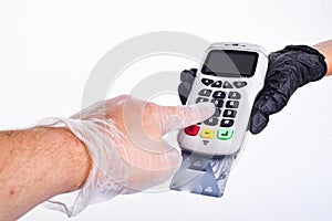 The sells submits a payment terminal. The buyer pays by card. Hands with gloves. Seller`s hand in a glove. Buyer`s hand in a glove