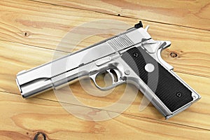 Semi-automatic handgun on grey wooden background, .45 pistol.