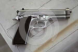 Semi-automatic handgun on grey wooden background