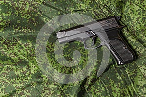 Semi-automatic pistol on pixel camouflage background