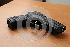 Semi-automatic pistol on wooden table. Standard handgun