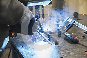 Semi-automatic welding with sparks and smoke at the factory