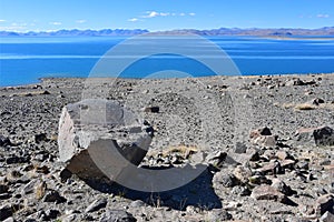 Semi-circular stone with a hole on the shore of the sacred Tibetan lake Tere Tashi Namtso