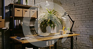 A semi-closed laptop lies on a table in a modern stylish office, without people