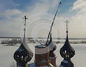 Semi-destroyed dome crosses of the abandoned church in the Yaroslav region in winter, Russia