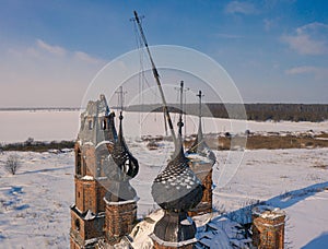 Semi-destroyed dome crosses of the abandoned church in the Yaroslav region in winter, Russia