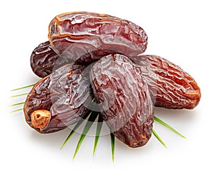 Semi-dried dates or date palm fruits lie on palm leaves isolated on white background. File contains clipping path photo