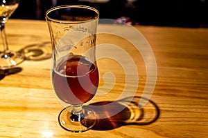 Semi empty beer cup on pub wood table