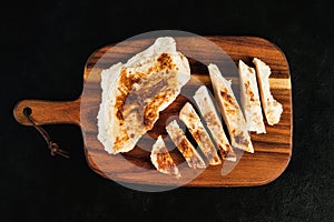 Semi-finished chicken fillets,lightly fried,on a dark background .Half-finished.Quick cooking at home.Fast food.Chicken