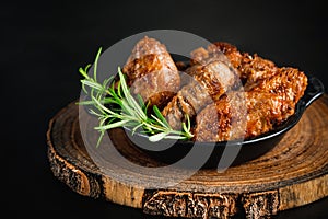 Semi-finished chicken wings on a dark background.Half-finished. Quick cooking at home. Fast food.Chicken wings fried