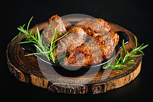 Semi-finished chicken wings on a dark background.Half-finished. Quick cooking at home. Fast food.Chicken wings fried