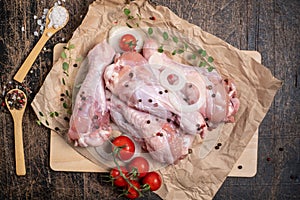 Semi-finished poultry products. Raw turkey wing surrounded by vegetables, spices and herbs on a dark wooden background