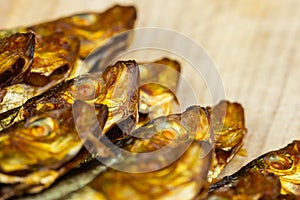 Semi macro of smoked sprats on wooden cutting board