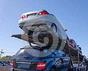 Semi trailer truck hauling load of cars down road