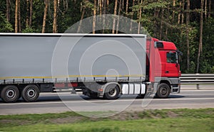 Semi-trailer truck moves along a suburban highway