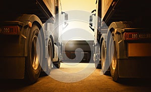 Semi Trailer Trucks Parked Lot at the Warehouse in Sunset. Big Rig Semi Truck Wheels Tires. Shipping Freight Truck Logistics.