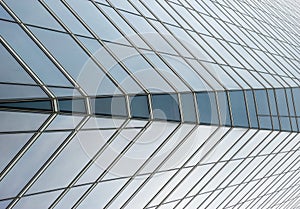 Semi-transparent glass windows of a skyscraper wall, with a change of symmetry in the center windows, with vanishing point