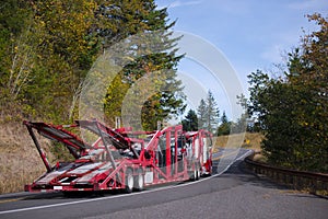 Semi Truck Car Hauler Red trailer on autumn winding road