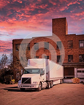 Semi Truck at customer Loading dock at sunrise