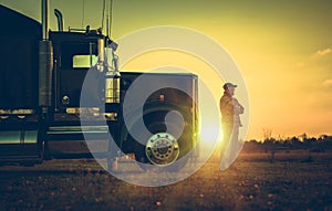 Semi Truck Driver in Front of His Vehicle During Scenic Sunset