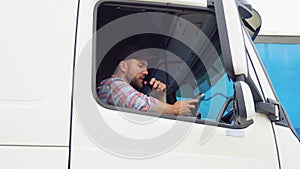 Semi Truck Driver Making Conversation with Other Truck Drivers Through CB Radio. Right Hand Drive Car