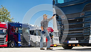 Semi Truck Driver Standing by Truck in Parking Lot