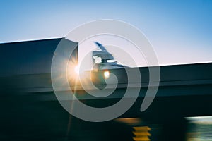 Semi truck on highway overpass concept with motion blur