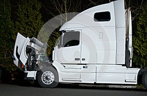 Semi truck with open hood and engine repairs