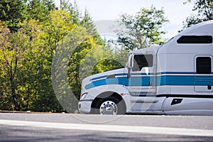 Semi truck powerful profile on road with autumn trees