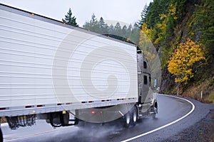 Semi truck and reefer trailer wheels in autumn rain dust