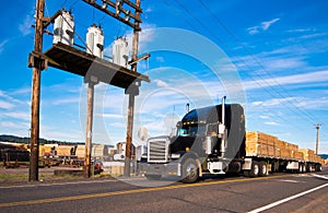 Semi Truck with timber near an electrical substation