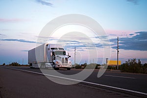 Semi truck trailer going on Arizona road in sunset