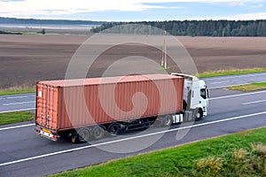 Semi Truck transport the sea container on highway. Shipping Containers Delivery by road, Maritime Services and Transport logistics