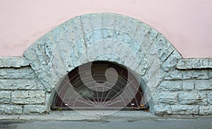 Semicircular basement window with metal barrier