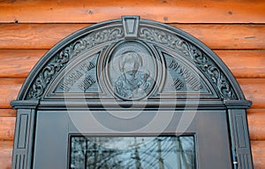 A semicircular door platbands depicting the Virgin with a child and the words  `Blessed Virgin Mary, save us.Russian text