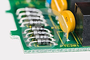 Semiconductor diodes and yellow resettable fuses in PCB detail on white background