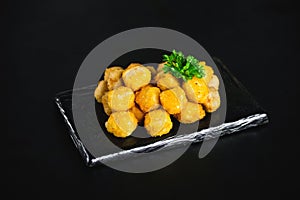 Semifinished chicken nuggets from chicken fillet on a dark background . Quick cooking at home. Fast food. Breaded