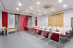 Seminar presentation. Empty conference room, lots of empty seats. Auditorium for workshops and seminars. Red color.