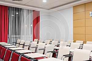 Seminar presentation. Empty conference room, lots of empty seats. Auditorium for workshops and seminars. Red color.