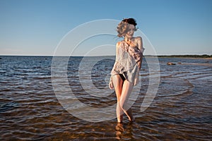 Seminude woman against sea background