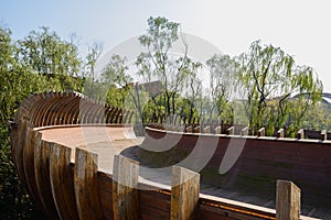 Semitubular wooden footbridge in air at sunny noon