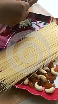 Semiya milk payasam preparation by crushing vermicelli.