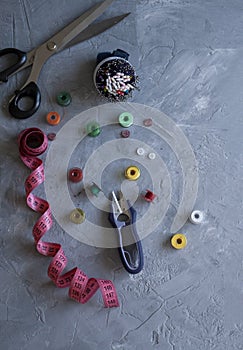A sempstress inventory: measure tape, buttons, needles, threads and scissors