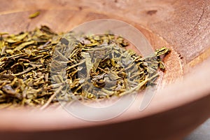 Sencha japanese dried green tea leaves in a wooden dish