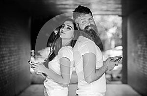 Send provocative message. Couple ignore real communication. Couple chatting smartphones. Girl and bearded man stand back