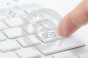 Sending email. gesture of finger pressing send button on a computer keyboard.