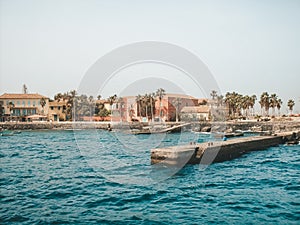 Senegal beach with concrete pier and architecture, view from water