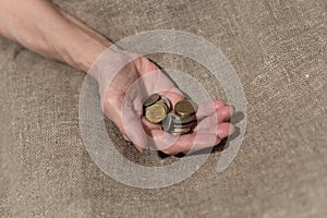 Senile hand hold a handful of small coins