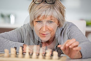 senile old woman playing game chess alone photo