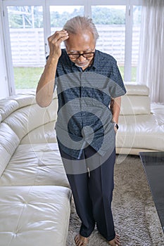 Senile senior man thinking something at home